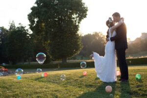 Fotograf ślubny Katowice – para młoda w parku o zachodzie słońca wśród kolorowych bańek mydlanych